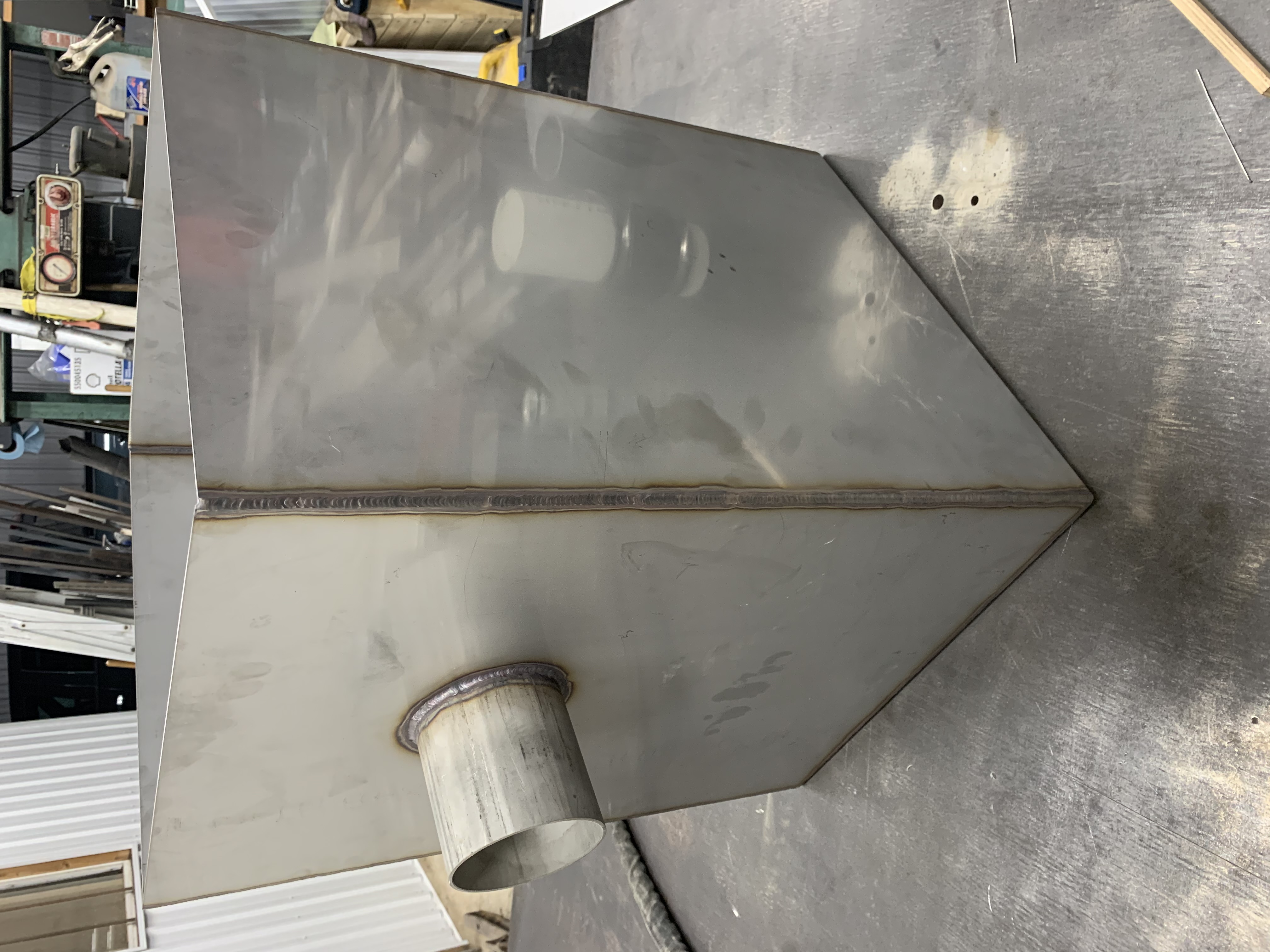 Well-fabricated metal box or tank, possibly stainless steel judging by the clean welds and finish. Shows precision fabrication.